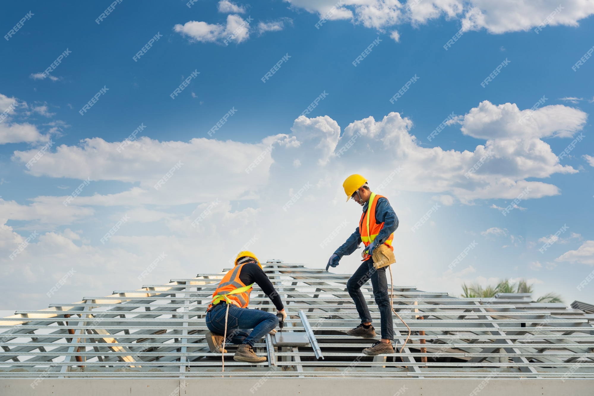 trabajador de techado con uniforme protector y guantes, herramientas para  techos, instalación de techos nuevos en construcción, taladro eléctrico  usado en techos nuevos con láminas de metal. 15632779 Foto de stock en