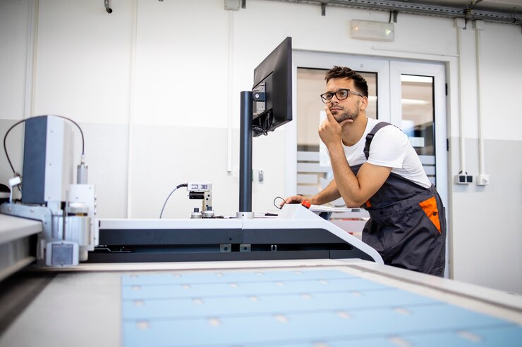 Foto trabajador técnico experimentado que intenta resolver el problema en la máquina industrial cnc.