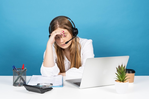 Trabajador de telemercadeo cansado frente a la computadora portátil