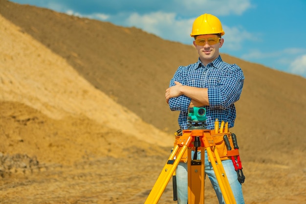 Trabajador con teodolito en obra