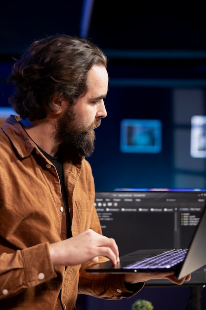 Trabajador de TI comparando el código de software entre la computadora portátil y el monitor de la PC