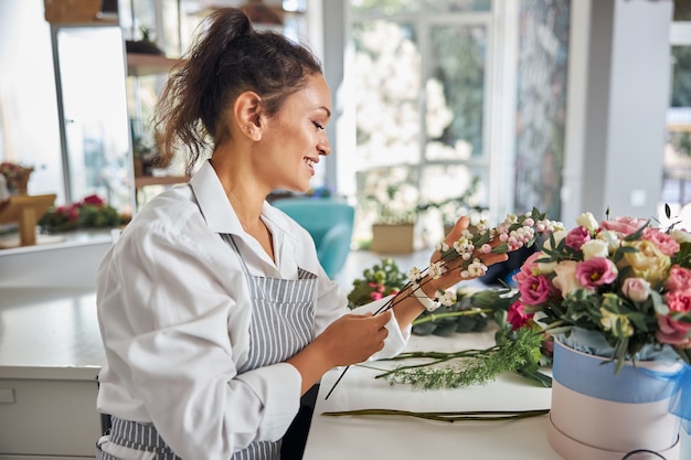 Trabajador de la tienda de flores creativa recogiendo una rama para un ramo