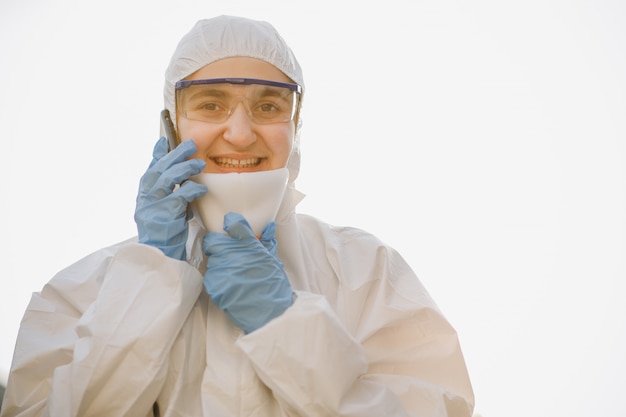 Trabajador en traje de protección química en un blanco. Médico epidemiólogo luchando con coronavirus COVID-19. Amenaza pandémica de protección contra coronavirus Covid-19.