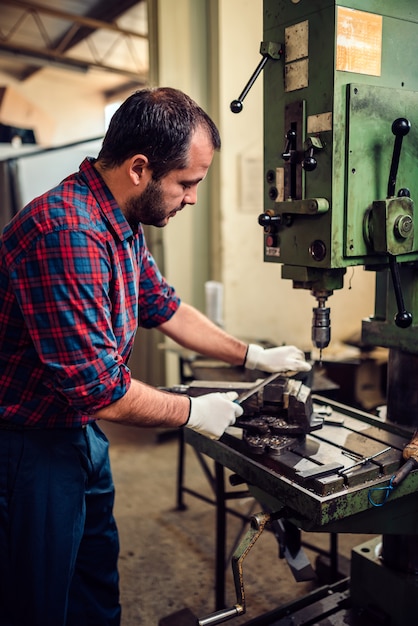 Trabajador utilizando lima de metal en una fábrica.