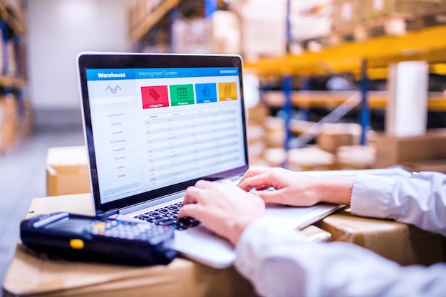 Trabajadora de almacén o supervisora con computadora portátil