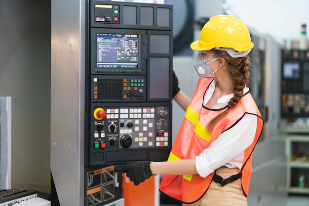 Trabajadora con chaleco de seguridad y casco amarillo en el trabajo