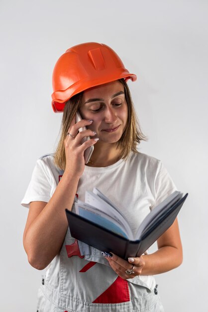 Trabajadora de la construcción sosteniendo una carpeta con documentos en sus manos Aislada en una llanura