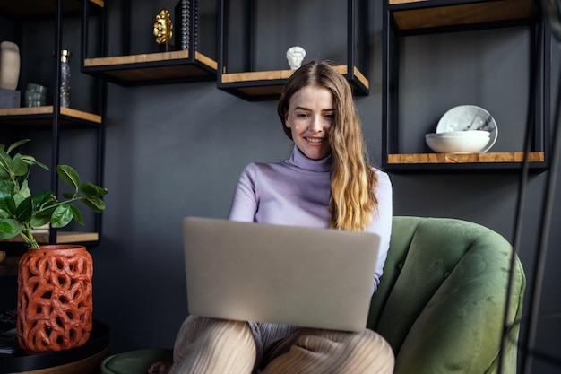 Una trabajadora independiente en un hotel utiliza una comunicación de trabajo portátil en el lugar de trabajo con un cliente por correo