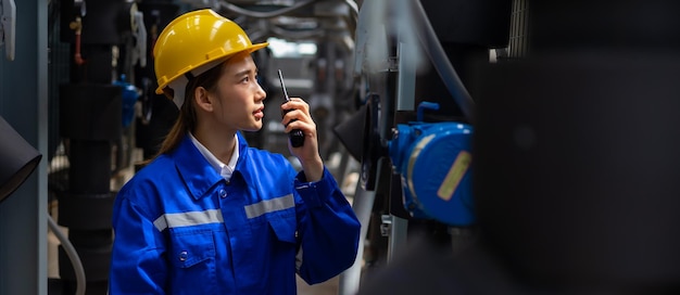 Trabajadora ingeniera asiática que trabaja y se comunica por radio con transmisor walkie talkie Edificio moderno en la azotea en la ciudad urbana