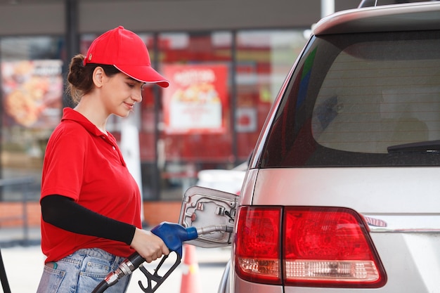 Foto trabajadora llenando gasolina en un coche