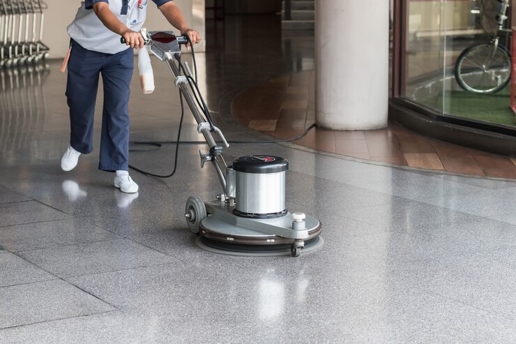 Trabajadora que limpia el piso con la máquina pulidora