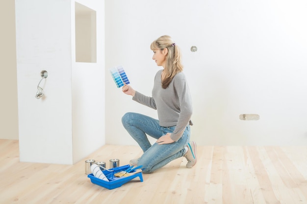 Trabajadora sentada en un piso de madera con paleta de colores