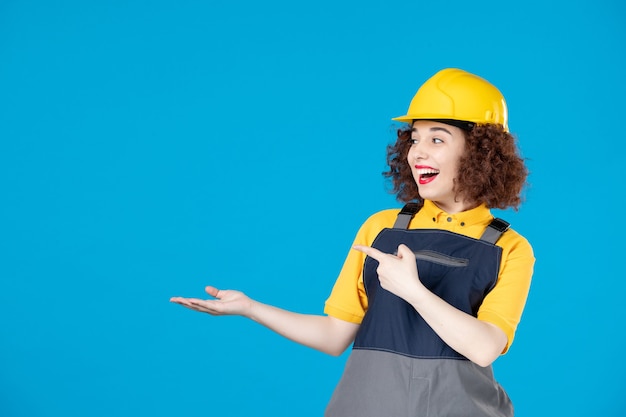 Trabajadora en uniforme amarillo y casco en azul