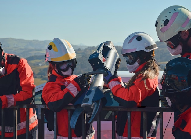 Trabajadoras sosteniendo mandíbulas de vida para abrir un auto accidentado