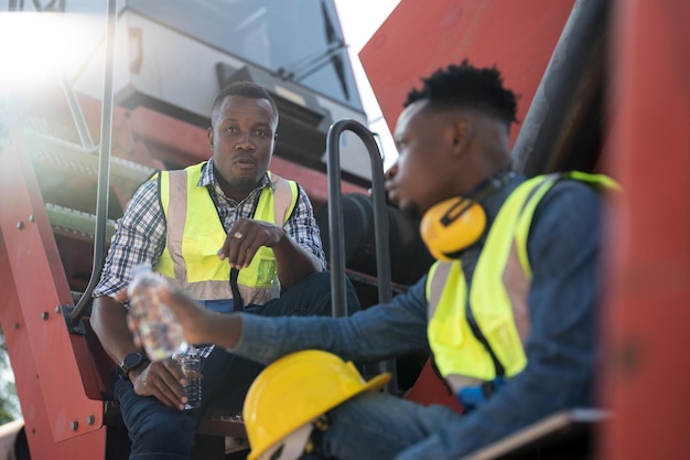 Trabajadores africanos Ingeniero Técnico sentado y gente de agua potable descansando después de trabajar