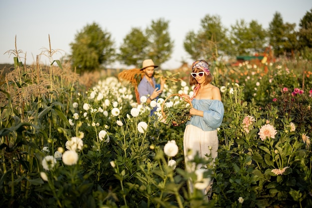 Los trabajadores agrícolas llevan muchas flores recién recogidas en la granja