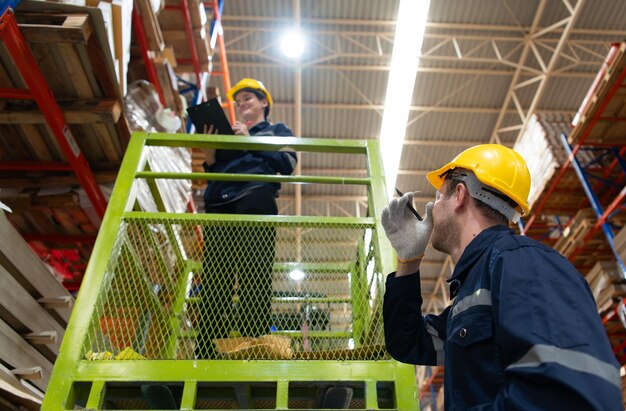 Foto trabajadores de almacén que usan una carretilla elevadora para comprobar y contar en un gran almacén.