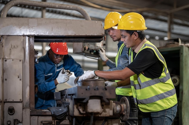 trabajadores asiáticos y fábrica de hombres africanos que trabajan en el personal de capacitación en ingeniería de máquinas pesadas de acero