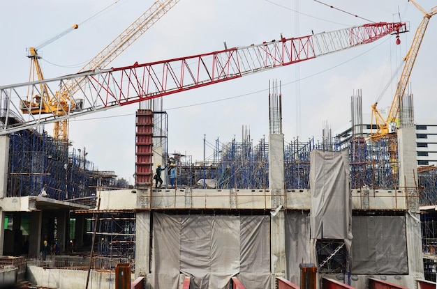 Los trabajadores asiáticos y los trabajadores tailandeses utilizan máquinas y maquinaria pesada constructores de obra nueva torre de construcción en el sitio de construcción edificio de gran altura en andamio en la ciudad capital de Bangkok Tailandia