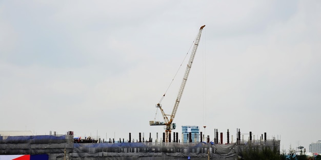 Trabajadores asiáticos y trabajadores trabajadores tailandeses utilizan máquinas y maquinaria pesada constructor de trabajo nueva estructura torre edificio alto en andamio en el sitio de construcción en la ciudad capital en Bangkok Tailandia