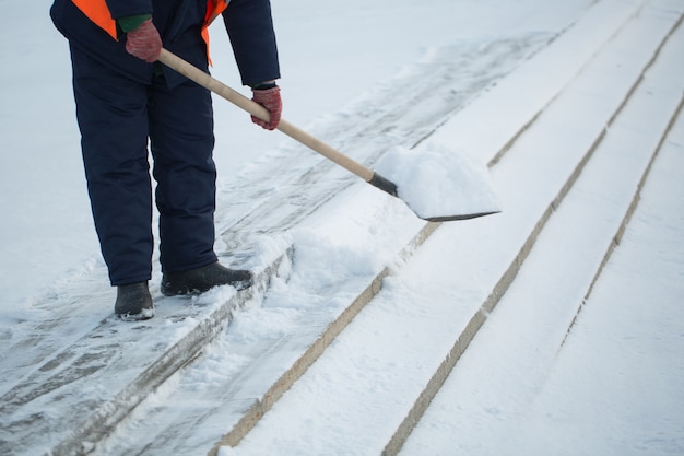 Los trabajadores barren la nieve de la carretera en invierno