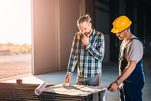 Trabajadores de la construcción comprobando comprobando impresión azul