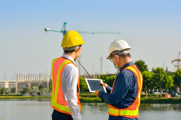 Los trabajadores de la construcción del equipo de ingenieros están planificando el proyecto de construcción en el sitio al aire libre