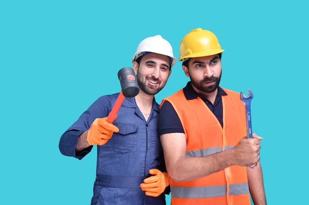 Los trabajadores de la construcción posando sobre fondo azul modelo paquistaní indio