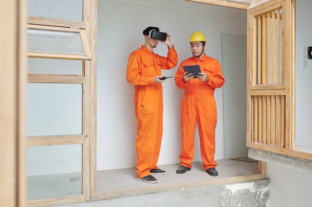 Trabajadores de la construcción que utilizan la aplicación de gafas vr para comprobar el aislamiento térmico de la nueva casa