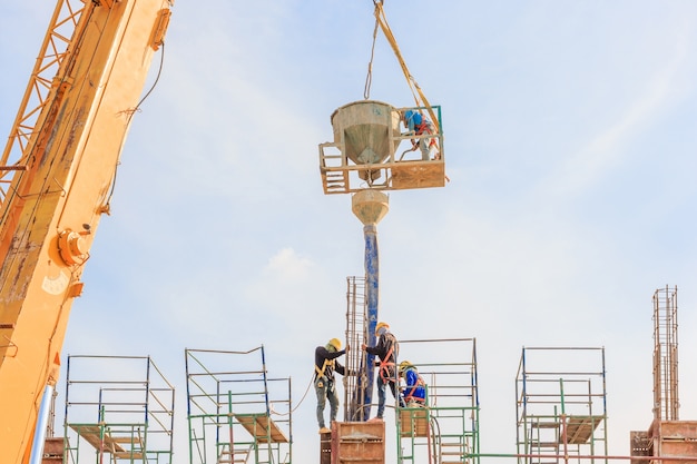 Trabajadores de la construcción trabajando en andamios a alto nivel.