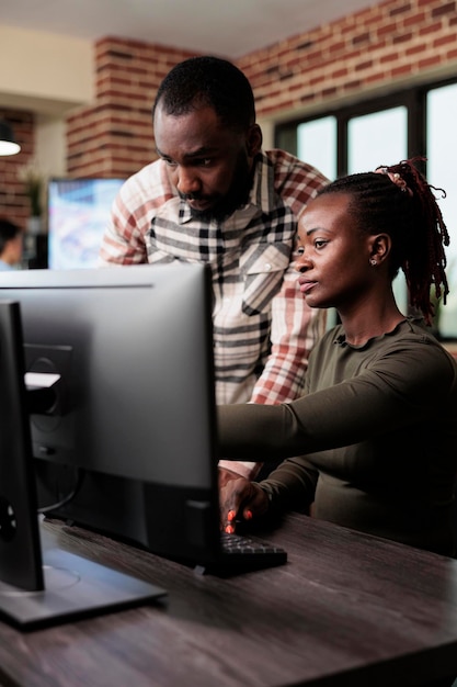 Trabajadores del departamento de producción de agencias creativas que intentan resolver problemas de desarrollo del proyecto 3D. Empleados de la compañía de software intercambian ideas de diseño mientras están sentados en el espacio de trabajo de la oficina.