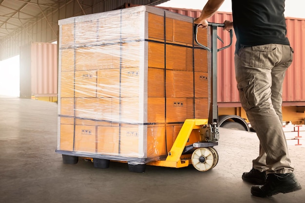 Foto trabajadores descargando cajas de paletas pesadas en camiones de contenedores cadena de suministro de envíos almacén de envíos