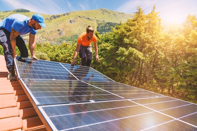 Los trabajadores ensamblan el sistema de energía con panel solar para electricidad y agua caliente.