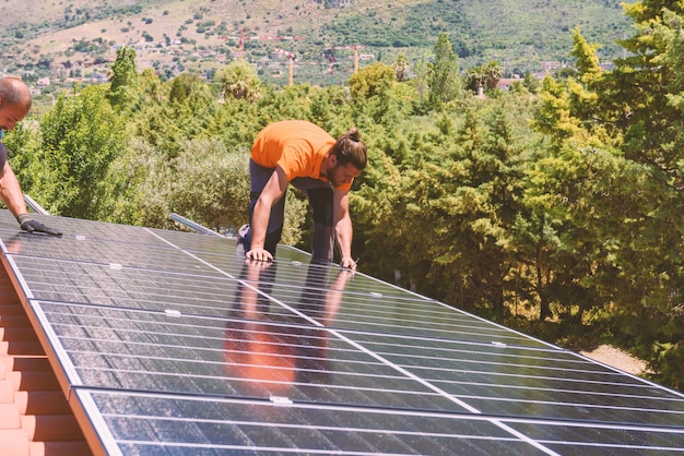 Los trabajadores ensamblan el sistema de energía con panel solar para electricidad.