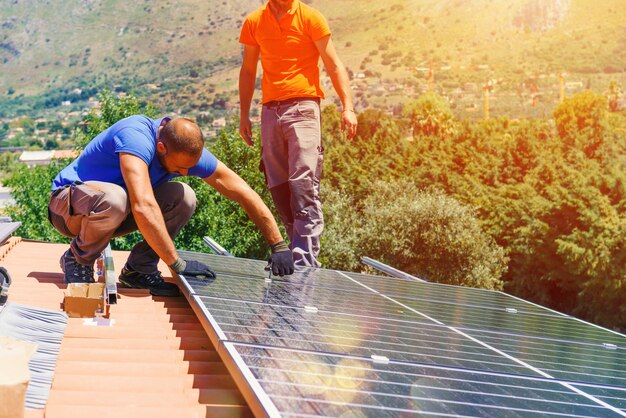 Los trabajadores ensamblan el sistema de energía con panel solar para electricidad.