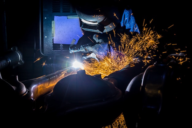 Los trabajadores están ranurando con alambres de soldadura de carbón con chispas