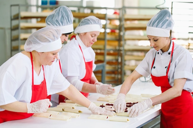 Trabajadores de la fábrica de confitería preparan postres con relleno