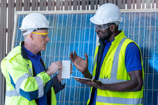 Trabajadores de la fábrica que muestran y controlan el panel de células solares para obtener tecnología sostenible