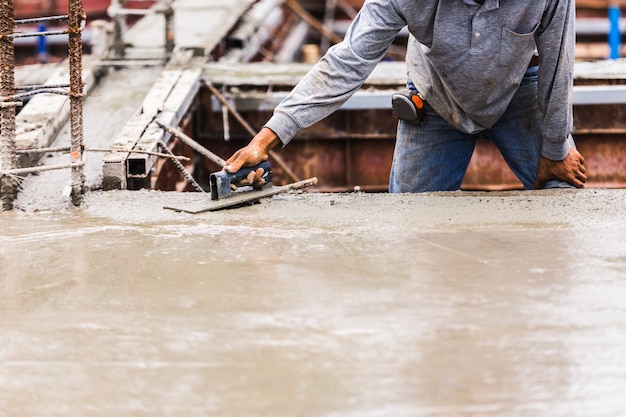 Trabajadores de la industria de la construcción trabajadores con la mezcla de hormigón herramienta en la construcción de pisos