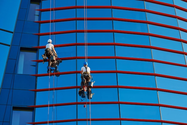 Trabajadores limpiando ventanas en el centro de negocios en scyscraper