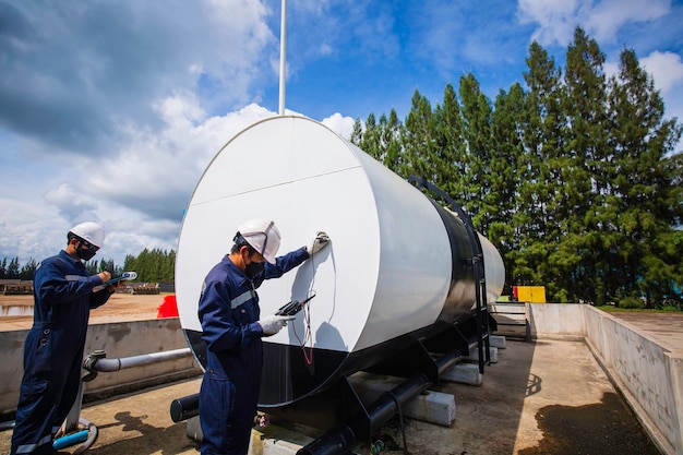 Los trabajadores masculinos son para la inspección del aceite del tanque de almacenamiento de espesor ultrasónico