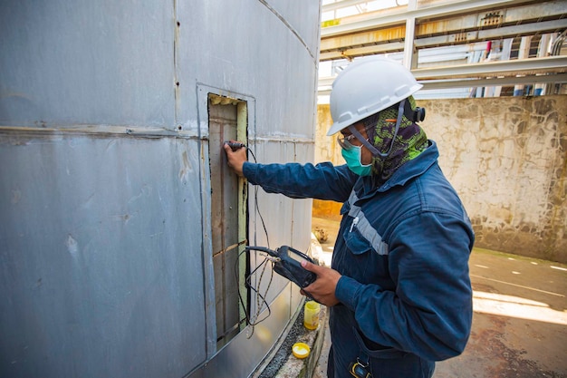 Los trabajadores masculinos son para la inspección del espesor del tanque ultrasónico