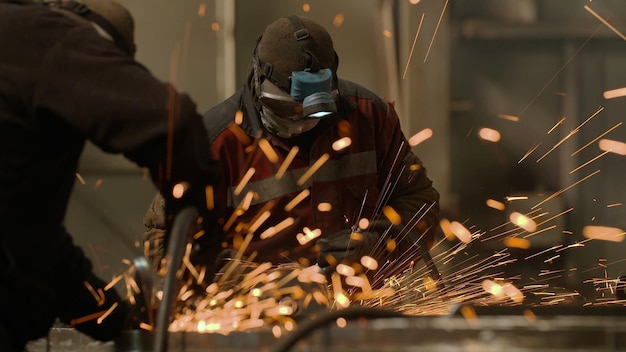 Trabajadores del metal en la fábrica de molienda con chispas