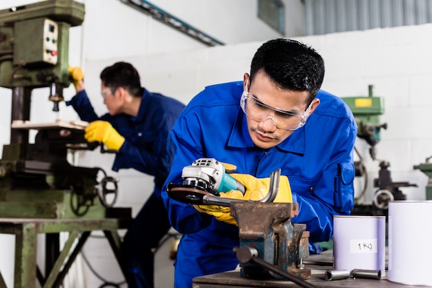 Trabajadores metalúrgicos en taller industrial de molienda