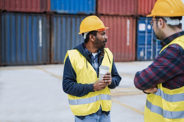 Los trabajadores que controlan los contenedores de envío en el puerto industrial al aire libre se centran en la cara del hombre indio