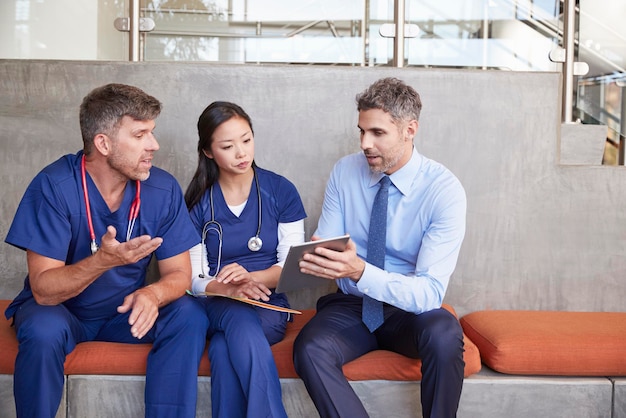 Trabajadores de la salud en discusión usando una tableta