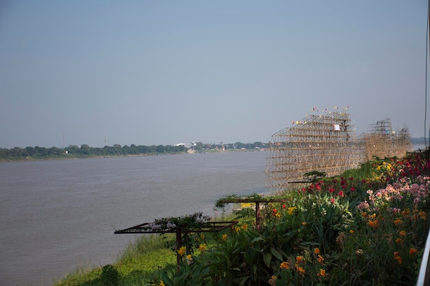 Los trabajadores tailandeses construyen un barco de bambú en el festival de la Procesión del Barco Iluminado o Lai Reua Fai y los viajeros buscan y se unen al evento en la orilla del río Mekong en Nakhon Phanom Tailandia