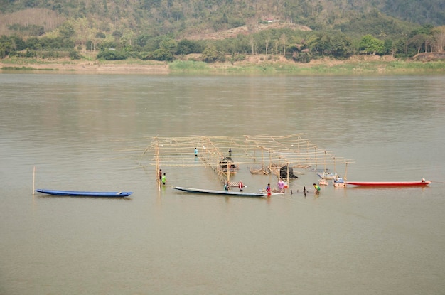 Los trabajadores tailandeses demolen la estructura de madera de un restaurante flotante en el río Mekong debido a la inundación en Kaeng Khut Khu en Chiang Khan el 21 de febrero de 2017 en Loei Tailandia