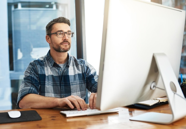 Trabajando para alcanzar sus objetivos Captura recortada de un hombre de negocios que trabaja en su computadora en la oficina