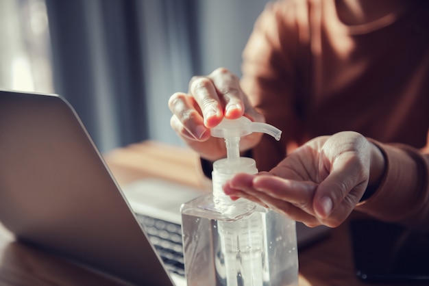 Trabajando desde casa, protección contra el virus Corona, Primer plano lavándose las manos con geles desinfectantes, Mujer en cuarentena por coronavirus con máscara protectora.